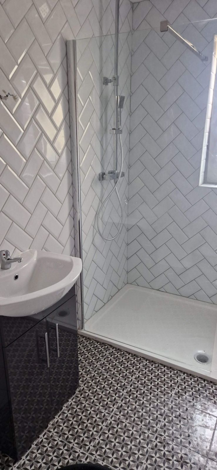 White herringbone-tiled shower room with patterned floor