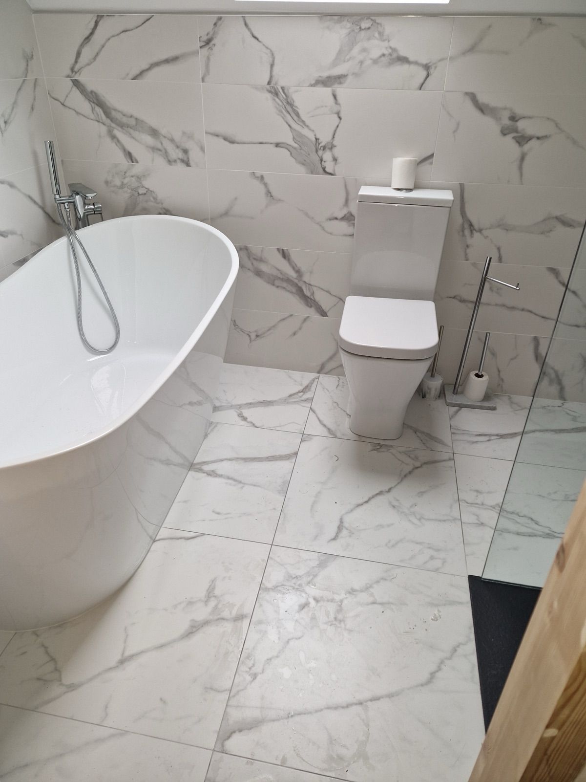 Marble-tiled bathroom with freestanding bath